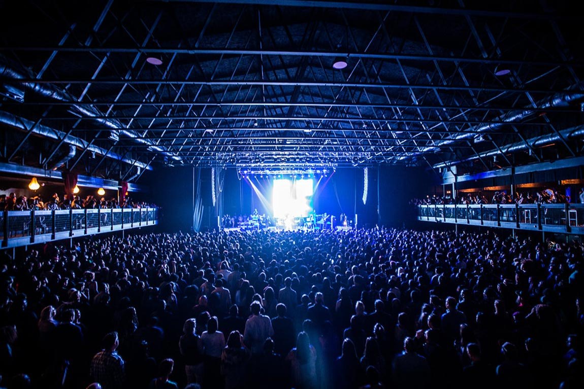 A packed general-admission crowd inside The Factory in Deep Ellum, Dallas — QTS Black Car & Limo transportation for September 2026 events